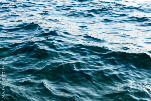 Fototapeta Naklejka Na Ścianę i Meble -  close up sea water surface. minimalist background with water texture in deep blue colors. gentle sea waves. soft liquid pattern
