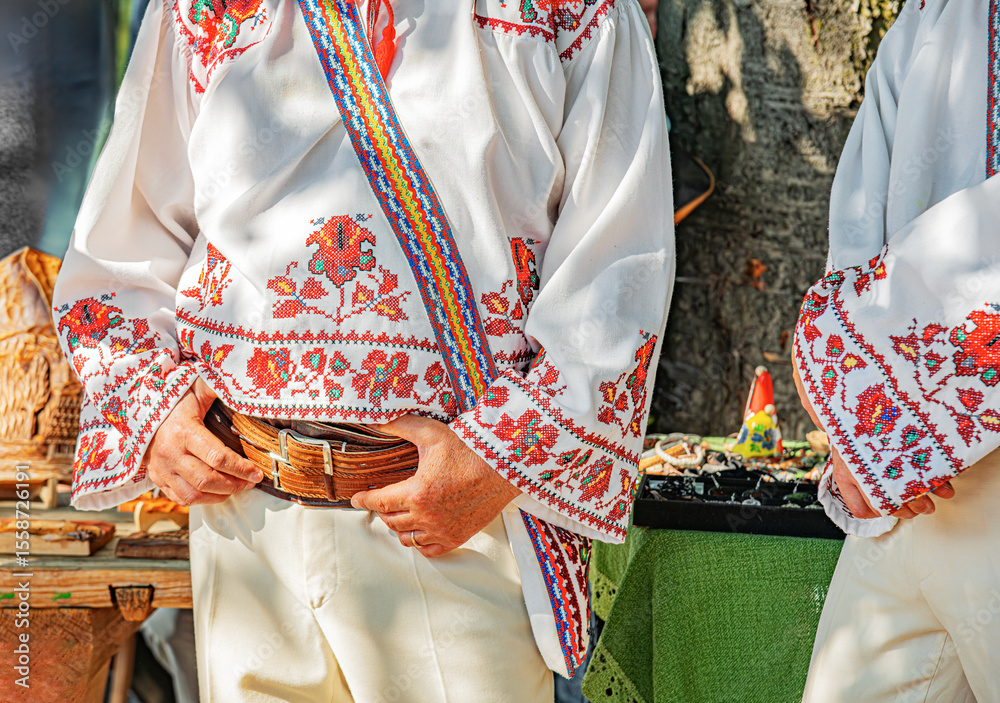 Naklejka premium Colorful traditional Eastern European folk costumes with intricate embroidery are worn during a lively outdoor cultural festival.