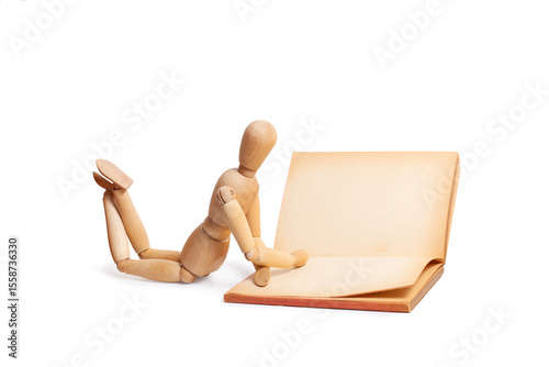 A wooden mannequin reading a book isolated on a white background photo