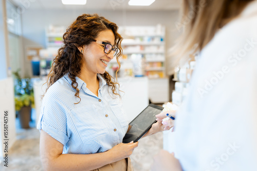 Photos Female commercial medical sales representative offering medicine samples to pharmacist at pharmacy
