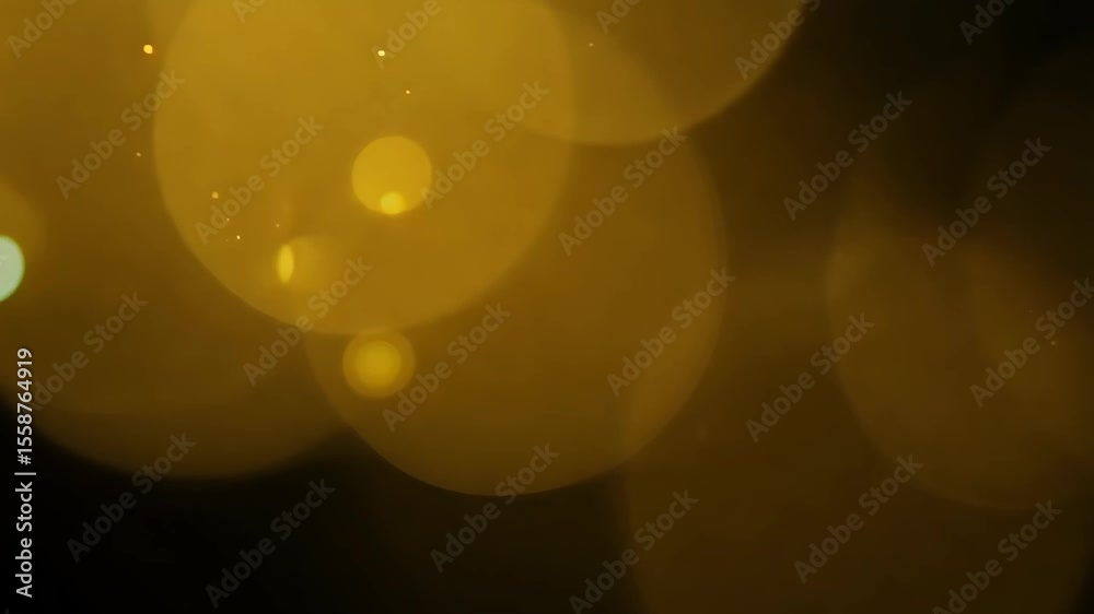 yellow bokeh dots drifting randomly against a dark background