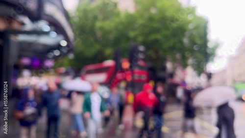 Wallpaper Mural Blurred view of a rainy London street, with umbrellas, red double-decker buses, and pedestrians crossing beneath dripping trees, atmospheric and moody, defocused Torontodigital.ca
