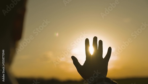 Canvas Print human hand at sunset in sky, dream of happiness, meditate in the rays of sunlight, catch bright orange light, travel on vacation, harmony of enjoying nature and relaxation, meeting sunrise, close-up