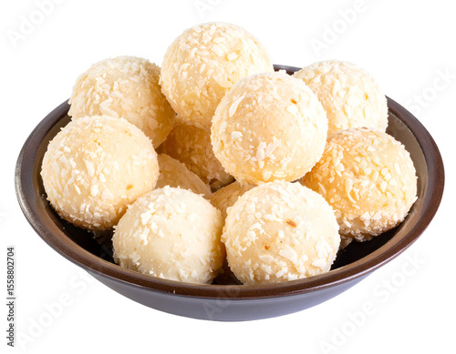 Golden-hued sweet treats, resembling brigadeiros or coconut balls, elegantly presented in a dark serving dish.