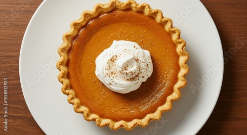 Top down view of whole pumpkin pie with whipped cream on top. Holidays and celebration, thanksgiving and halloween food. Traditional autumn or fall dessert. Cafes and bakeries, home cooking