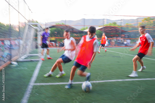  teens  boys plays football at a sports school .Blur