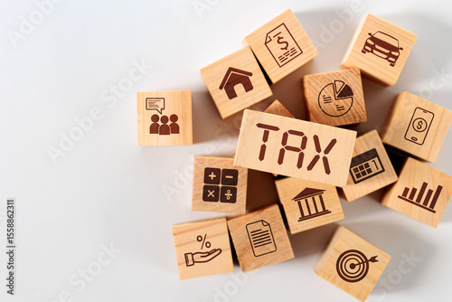 A central wooden block with TAX is surrounded by smaller blocks with icons for various taxable items like property, vehicles, and income.