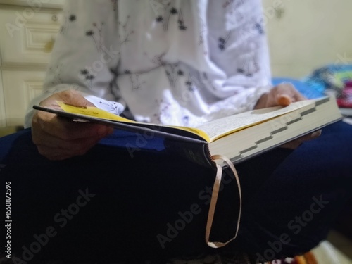 Fototapete A woman holding a holy Koran