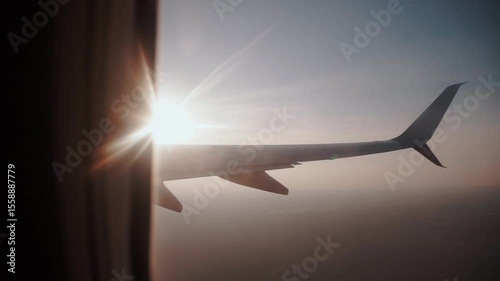 Airplane wing in the air high in the sky during a trip. Flight and travel around the world, view from the window of the porthole plane