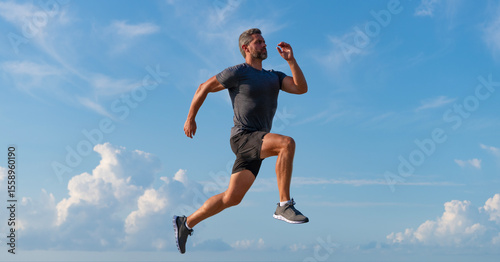 Runner man running. Fitness and sport. Man running against blue sky. Sport lifestyle. Sportsman running in summer. Sport runner training outdoor. Healthy lifestyle with daily run