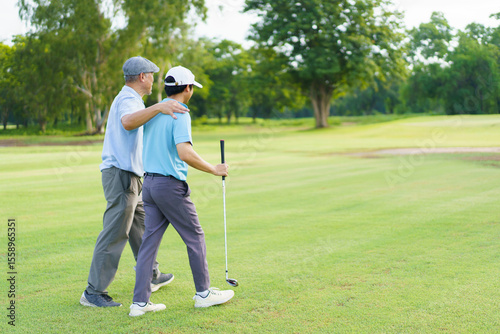 Asian man and elderly father are enjoy playing golf together with a good time.