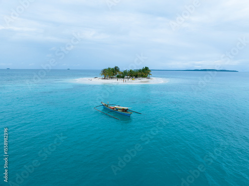 Aerial view of traditional Asian fishing boats near a small tropical island in the middle of the ocean