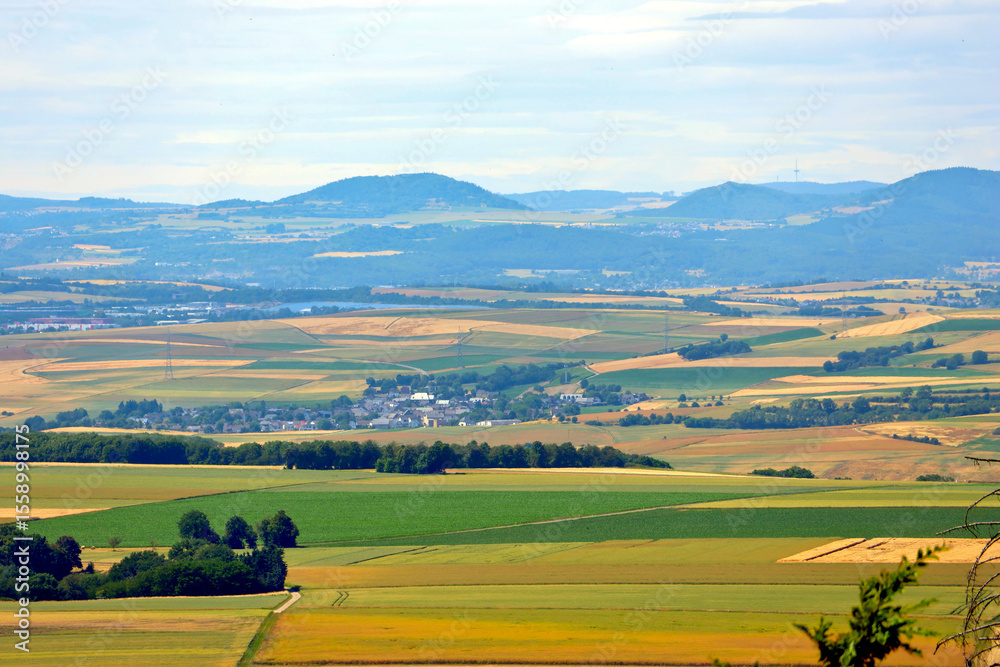 Fototapeta premium Aussicht vom Niederfeller Wald oberhalb der Mosel im Hunsrück in Richtung Vordereifel. Aussicht vom Traumpfad Bleidenberger Ausblicke bei Oberfell an der Terassenmosel im Landkreis Mayen-Koblenz. 