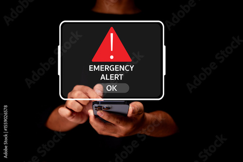 A person holding a smartphone displays a digital emergency alert notification with a red triangle warning symbol and an OK button.