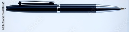 Navy ballpoint pen and shiny metal clip floating on a clean transparent base