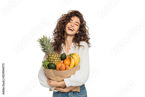 Happy woman holding a grocery bag full of fresh fruits.