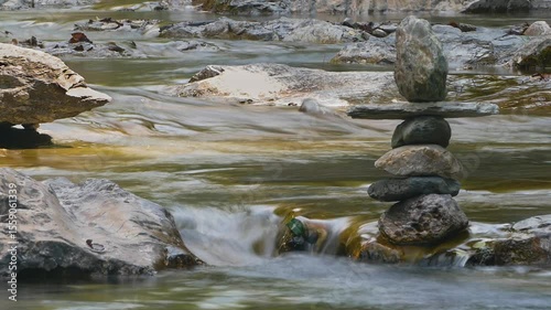 Stacked stones as water flows, a concept of balance and harmony. Long exposure, Silk effect.