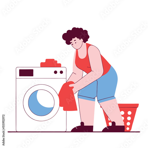 Person loading laundry into a washing machine with a laundry basket nearby