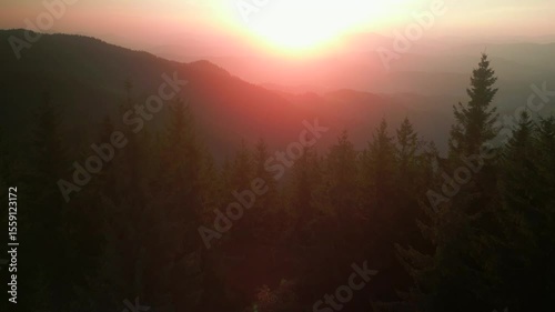 Mountains at golden hour aerial video 4k footage of a vibrant sunset, with fiery clouds stretching over a peaceful peaks as day turns to night, Sun goes under the peak