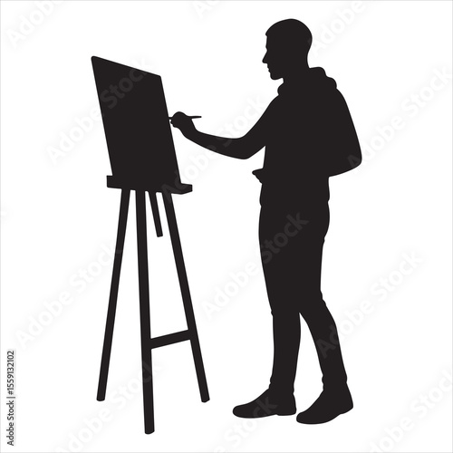 Silhouette of a young male artist painting on a canvas on an easel