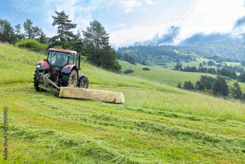 Obraz na płótnie Tractor Mowing Lush Hills in Presovsky Kraj, Slovakia