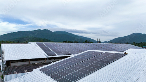 Rooftop solar panel installation set against a backdrop of lush green mountains, showcasing clean energy solutions in harmony with natural landscapes.