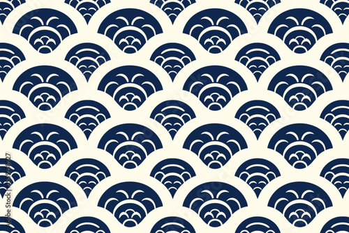 Repeating pattern of navy blue scalloped shapes with white accents on a cream colored background