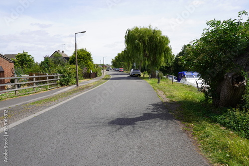 Wallpaper Mural Nottinghamshire, England - June 20 2025: Quiet residential street curving along a waterway, mixing nature and urban elements Torontodigital.ca