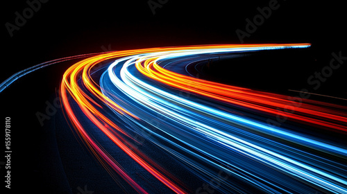 Dynamic streaks of light from cars create a mesmerizing blur on a winding road during a long exposure night shot.
