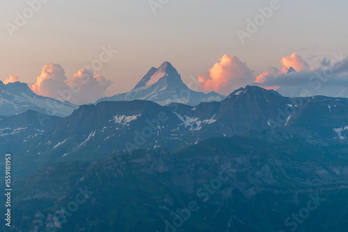 Sunrise over the Jungfrau region—first light kissing the snow-capped peaks, painting the sky in warm tones. A majestic alpine scene full of peace, power, and wonder. photo