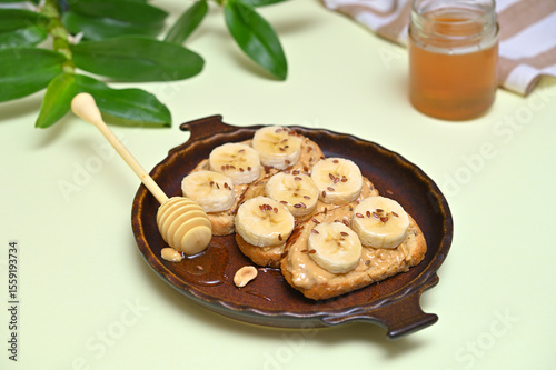 vegan toasts with peanut butter, banana and honey on a plate close-up