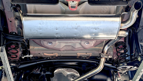 Exhaust system of a new car with exhaust pipe. View from below. Car reparation service concept