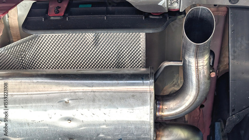 Close up of a car exhaust system with a pipe. View from below. Car technical elements , car servie concept