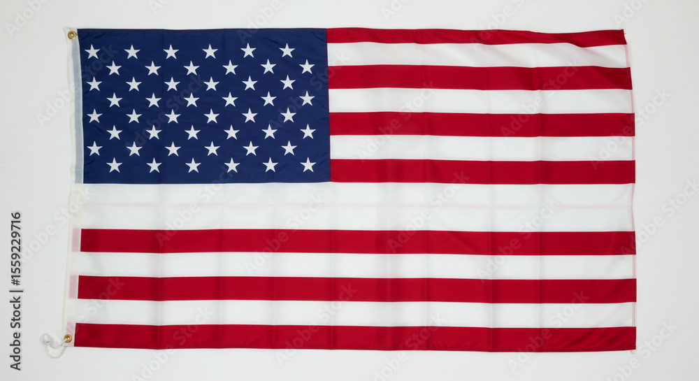 Fototapeta premium A us flag with stars and stripes hanging against a plain white background in a horizontal position