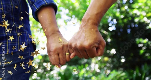 Senior couple extending hands toward camera hooking pinkies showing rings for health stars drifting