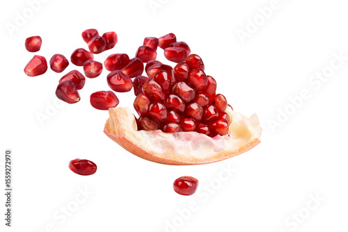 Healthy eating and antioxidant superfood concept with a fresh pomegranate slice and its ruby-red seeds.