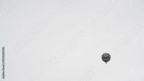 A hot air balloon with a basket flies across the evening sky. The silhouette of a balloon against the background of the evening sky on a white sky.