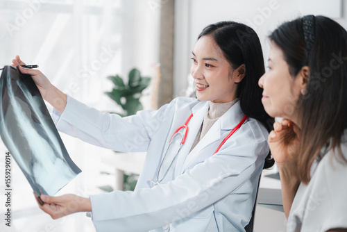 Asian Doctor Explaining X-ray to Patient in Clinic - Healthcare Professional Consultation Young Physician Diagnosis Medical Exam Treatment