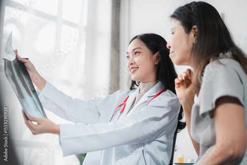 Asian Doctor Explains X-Ray Results to Patient Medical Exam Young Professional in White Coat Stethoscope Healthcare Consultation Lung Analysis Hospital Checkup