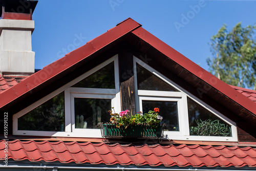 Canvas Print gable attic window with white frame and flower box on red tiled roof of cozy hou