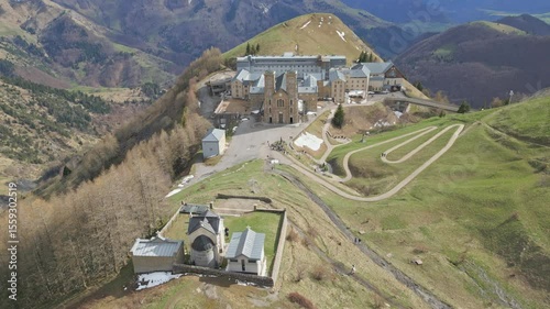 Panoramic view of the Basilica of Our Lady of La Salette in the French Alps, surrounded by lush forests and snow-covered mountains. Site of the 1846 Marian apparitions.