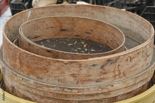 Wallpaper Mural Multiple wooden sieves are stacked on top of each other at a harvest site, revealing signs of use. Torontodigital.ca