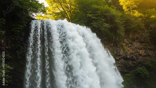 Majestic waterfall cascading down rocky cliff in forest