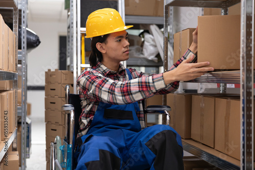 Asian employee with physical impairment processing parcels for local delivery, checking inventory and packages on depot racks. Storage room and shelves designed for accessibility.