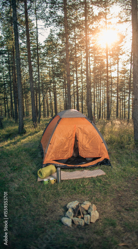 Morning Campfire Scene With Tent and Sleeping Bag in Pine Woods