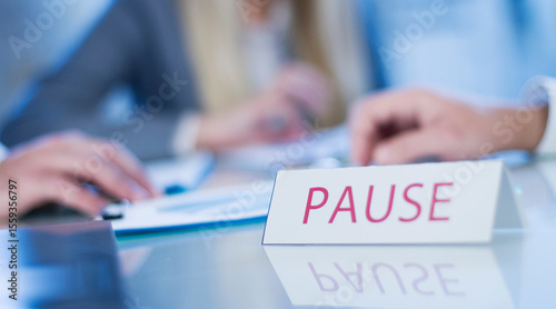Business Meeting on Hold With Pause Sign on Table