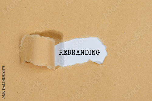 Картината върху платно The Text “REBRANDING” Appearing Behind Torn Brown Paper – Business Strategy Conc