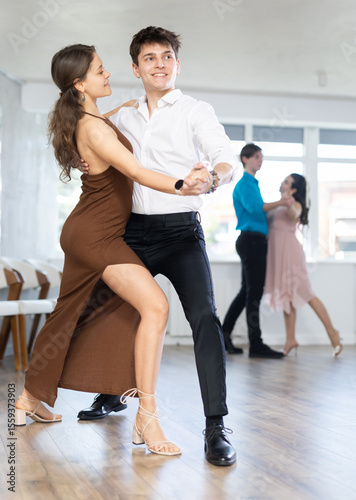 Young man and young woman dance couple latin dances in studio