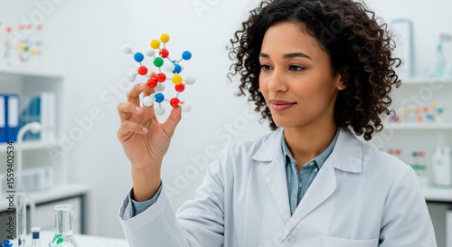 Female Scientist in Lab Coat Closely Examining a Colorful Molecular Model