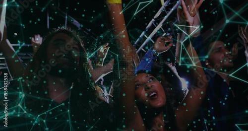 Mid adult woman raising arms joyfully initiating network overlay pulsing across concert crowd